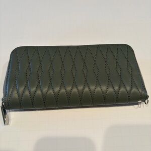 Dark gray quilted, zip around wallet with silver zipper coin area.